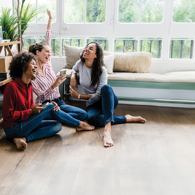 friends sitting on wood look flooring