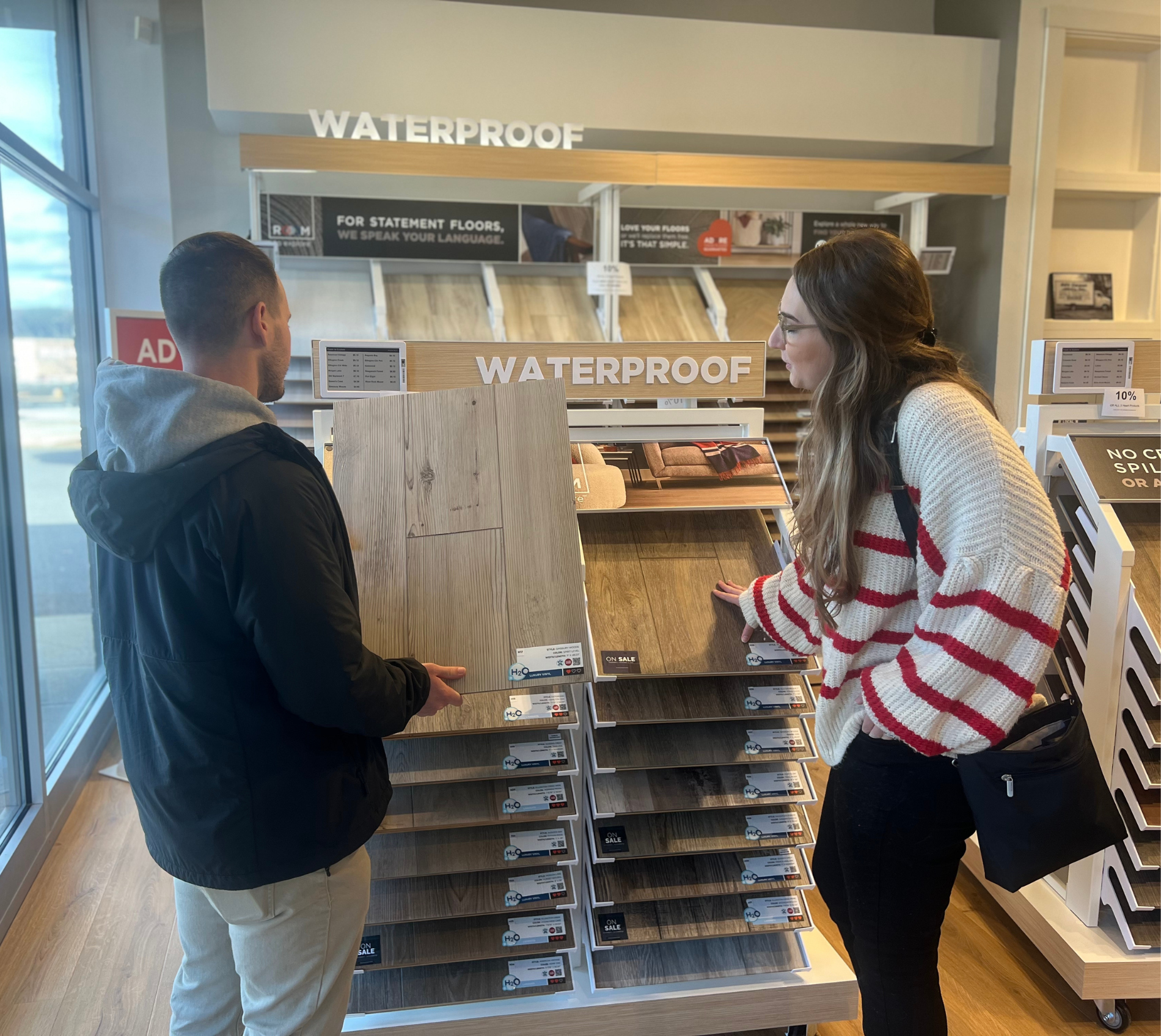 Women holding flooring sample in floor store 